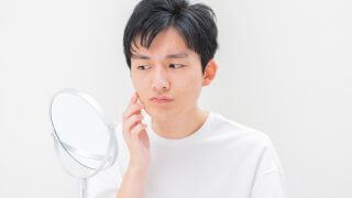 鏡を見つめる男性