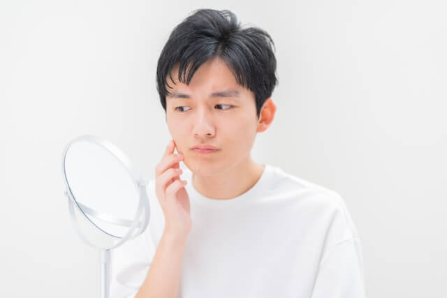 鏡を見つめる男性
