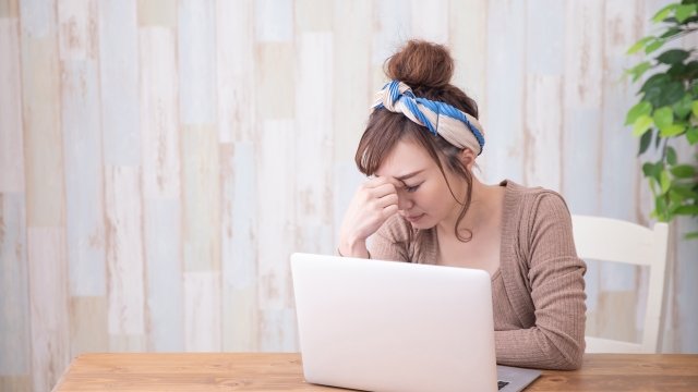 目頭を押さえる女性