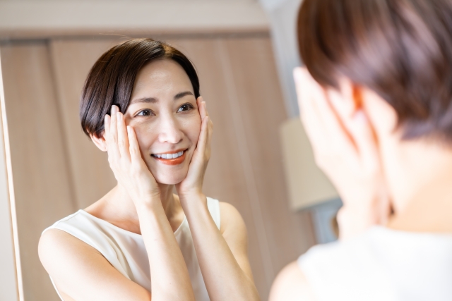 鏡で肌の調子を確かめる女性