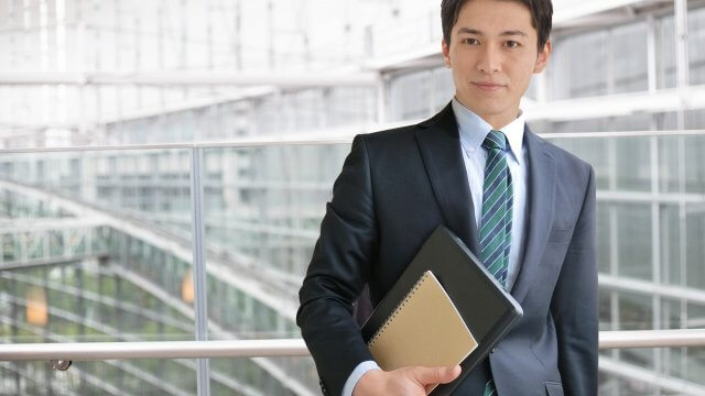 パソコンを持つスーツ姿の男性