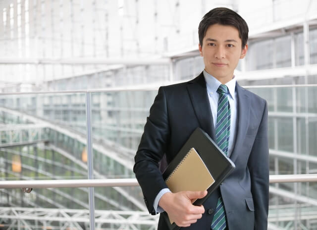 パソコンを持つスーツ姿の男性