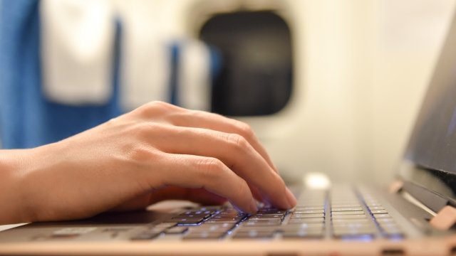 新幹線でパソコン作業をする手元